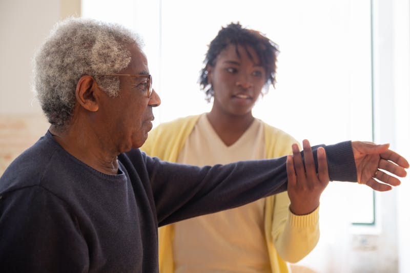 Elderly man receiving hands-on assistance from a dedicated caregiver