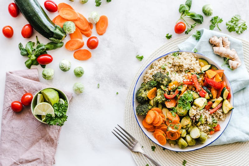 Fresh Mediterranean ingredients including tomatoes, peppers, and vegetables laid out for preparation