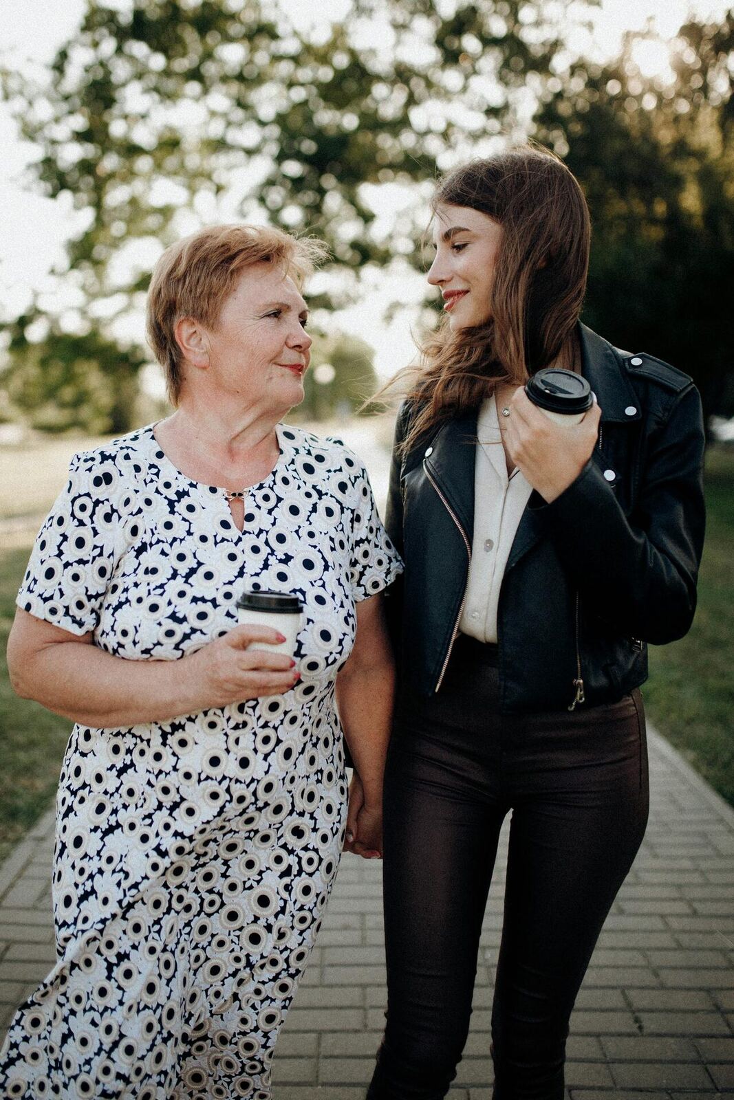 Adult daughter walking with elderly mother in Orange County park