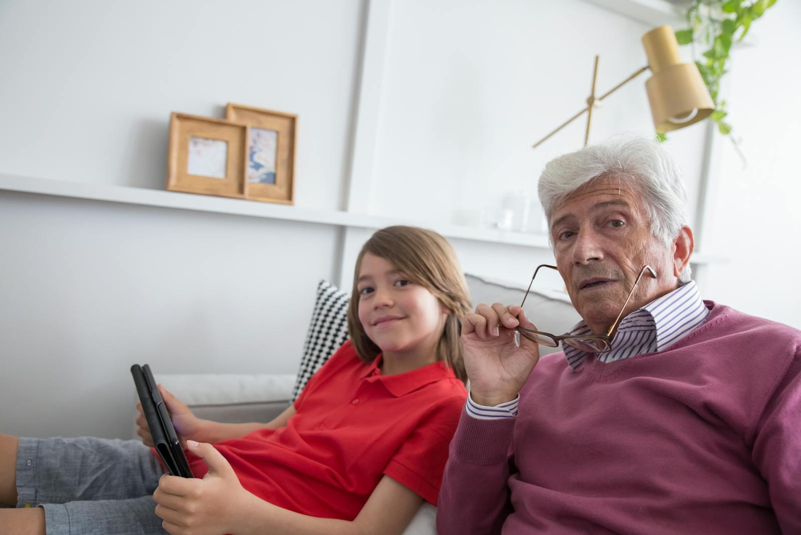 Grandfather and granddaughter using tablet together at home in Orange County