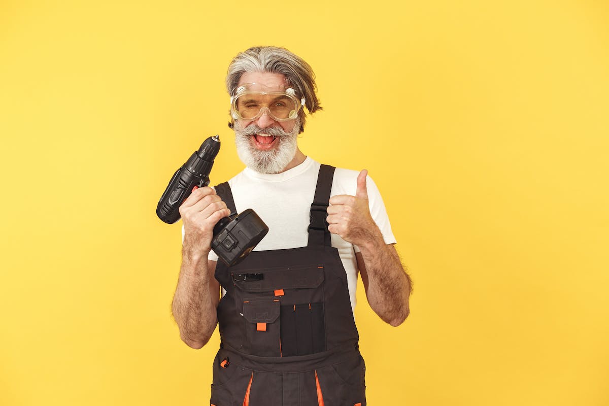 Contractor wearing safety glasses installs a home modification with a cordless drill