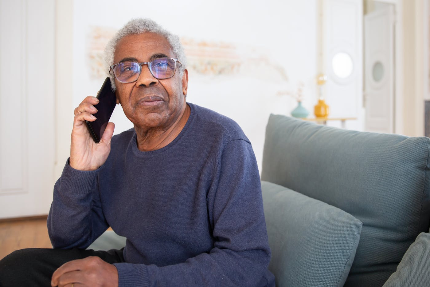 Senior man on a phone call at home, calling his Medicare Advantage plan to ask about in-home help benefits