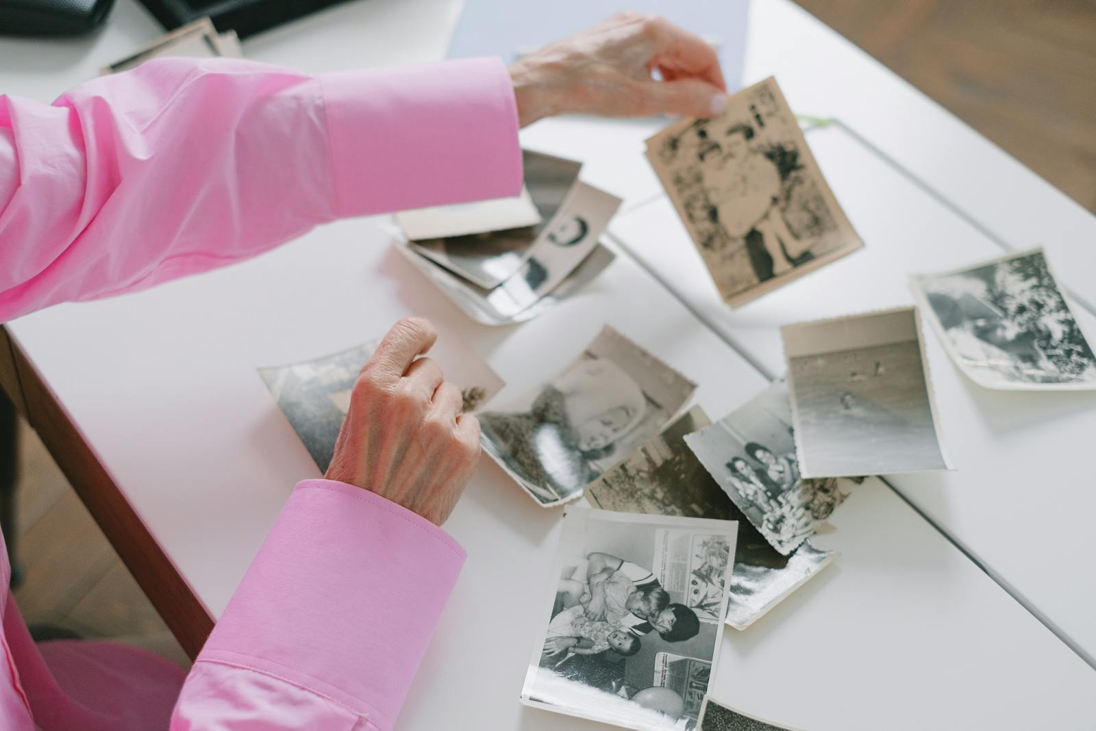 Senior woman quietly looking through old family photographs at home