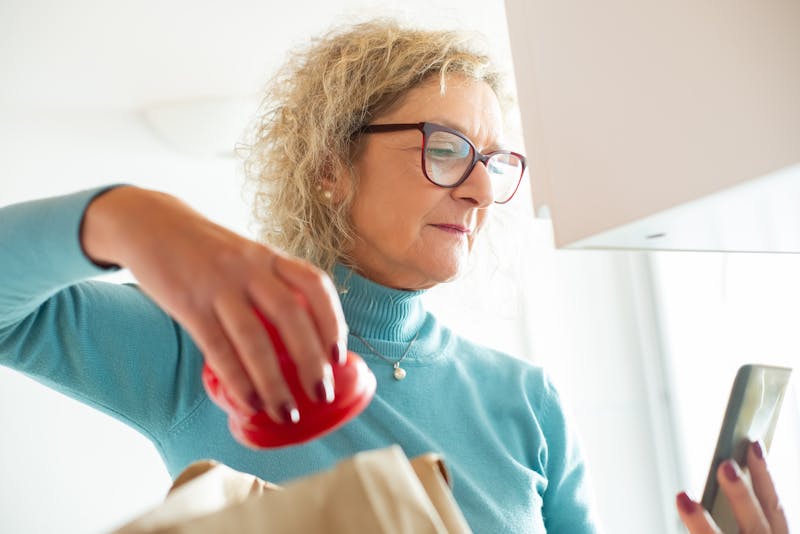 Senior woman with eyeglasses looking at her cell phone
