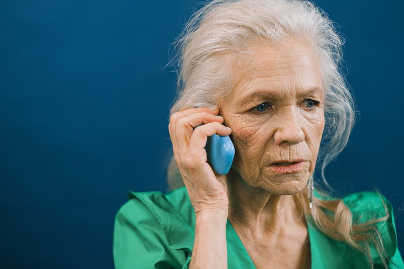 Elderly woman talking on the phone looking concerned