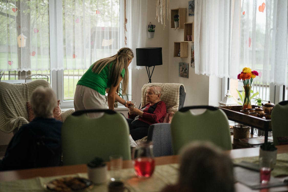 Home caregiver attentively helping elderly person in a care setting — awareness is the first line of defense