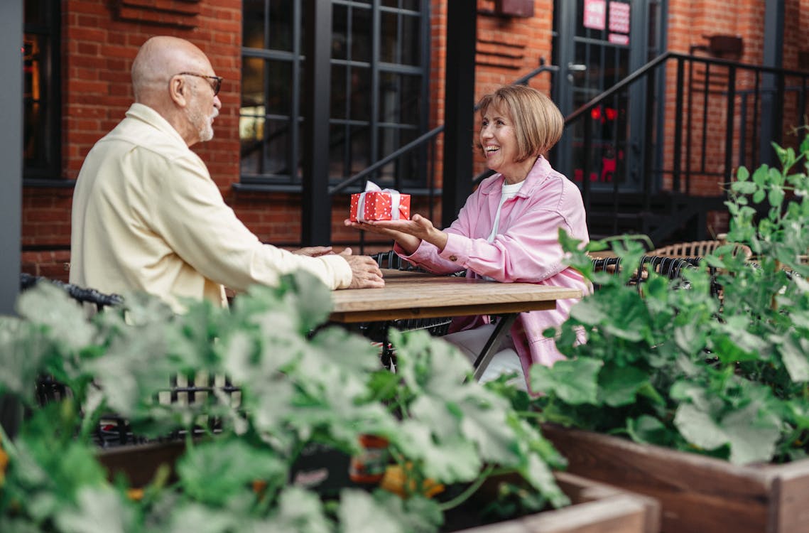 Elderly woman giving a gift to a family member at home