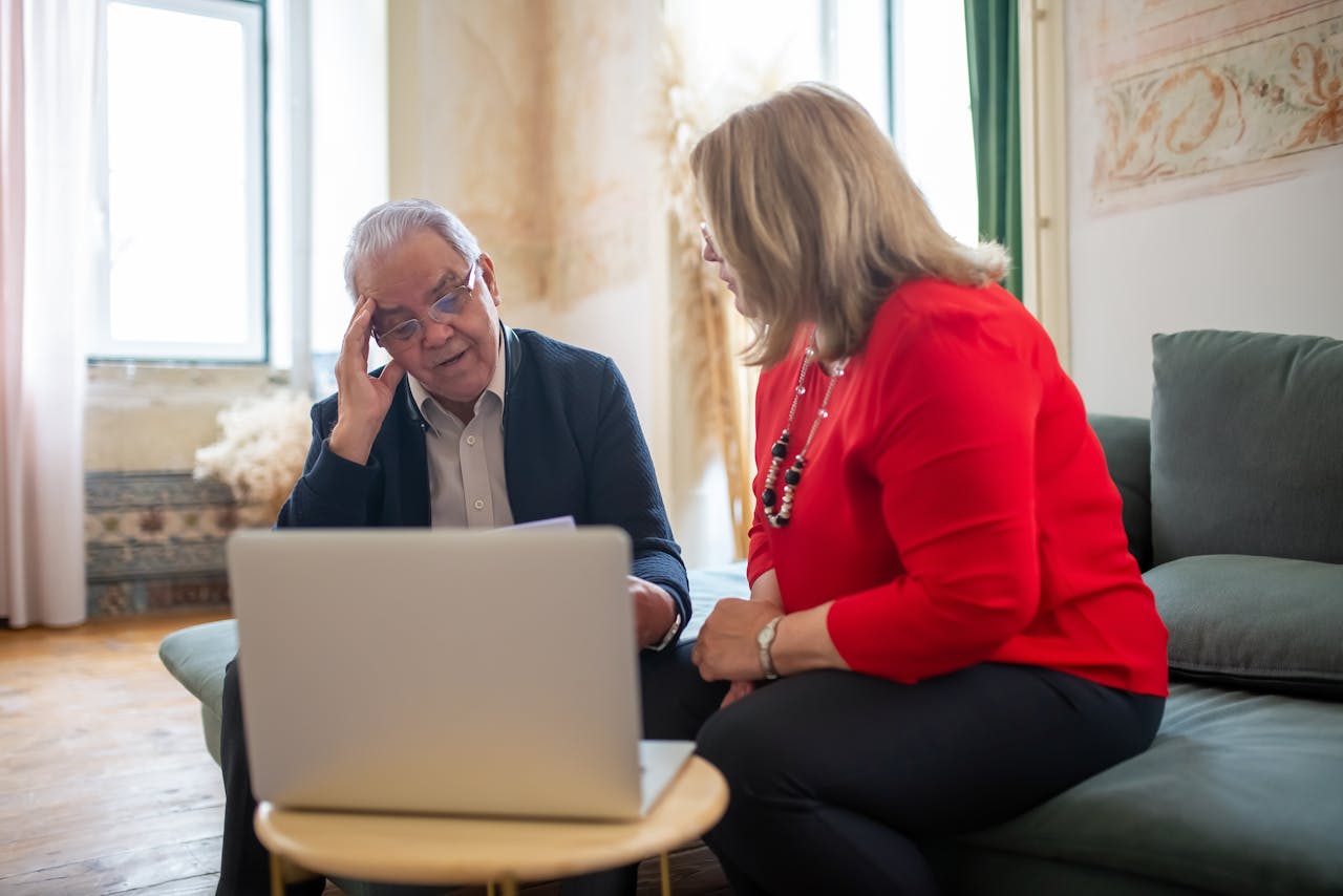 Elderly couple reviewing care plan documents with family advisor