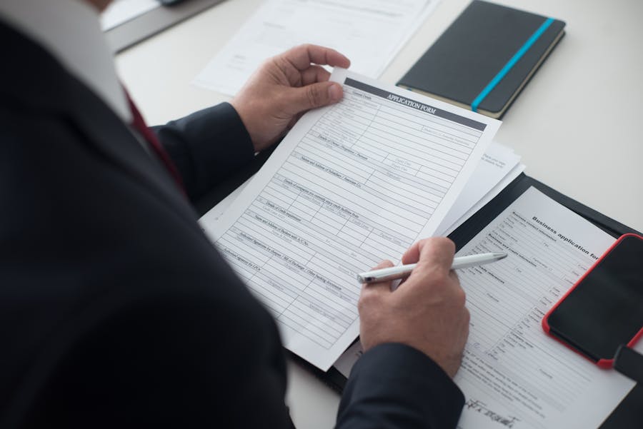 Man reviewing IHSS application form and required documents at desk