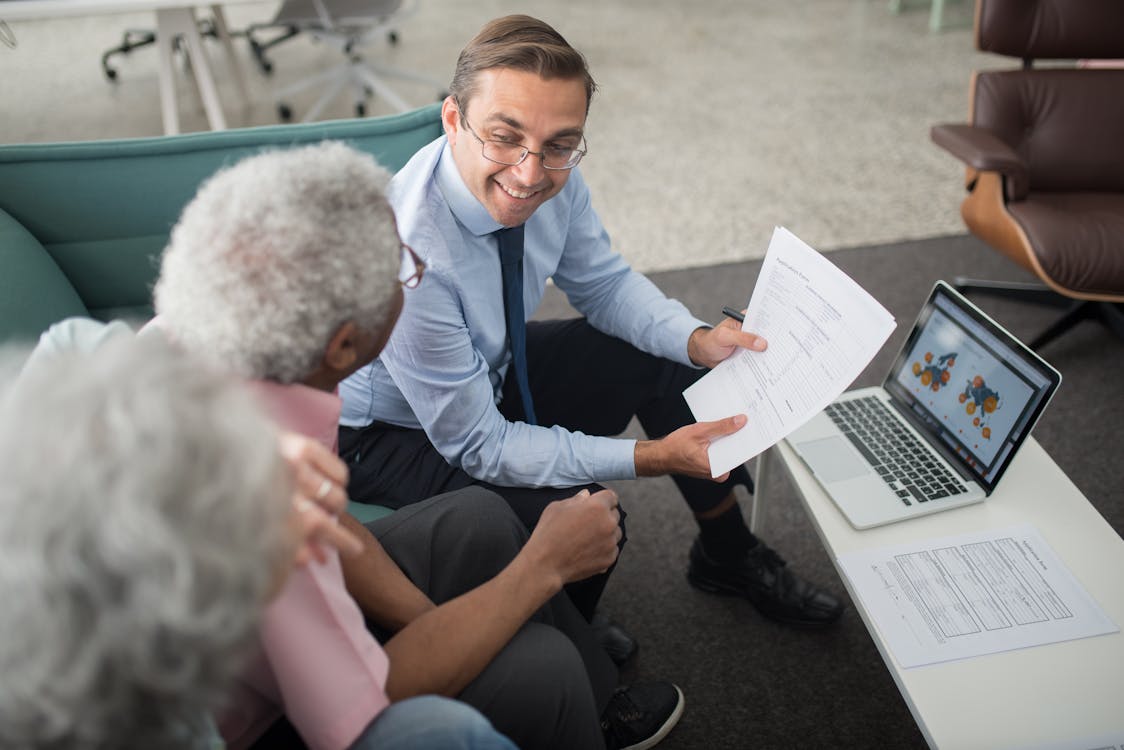 Knowledgeable benefits advisor explaining Medi-Cal Notice of Action documents and appeal options to an Orange County senior