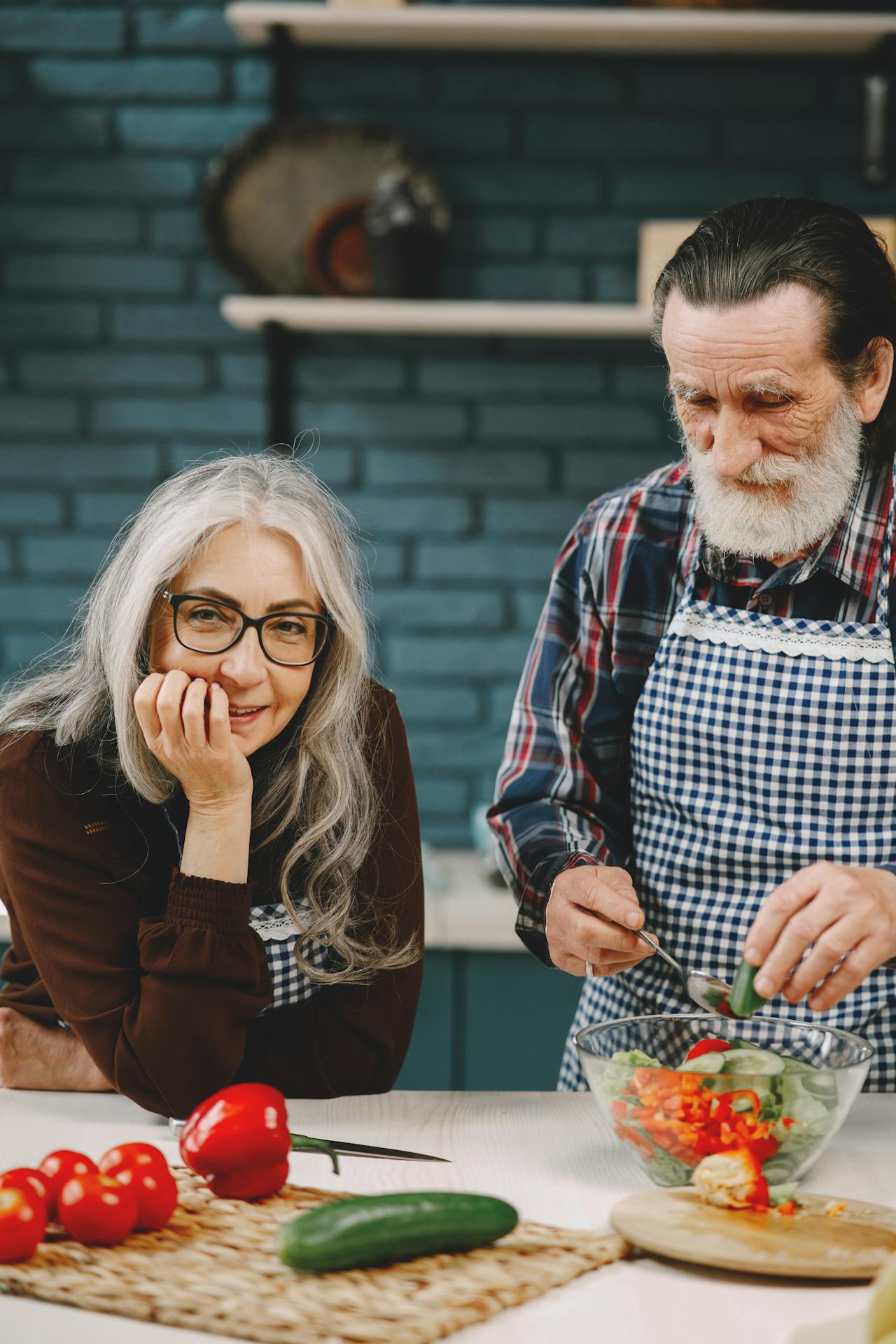 Older couple preparing a fresh salad together in their home kitchen
