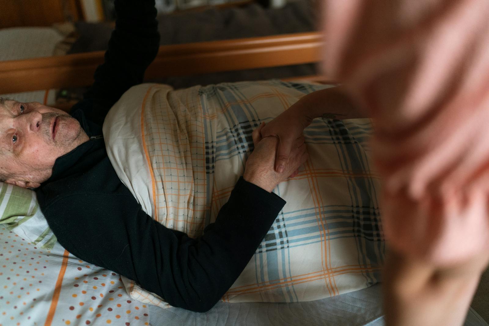 Caregiver holding a senior's hand during a daily wellness check-in - heat wave safety