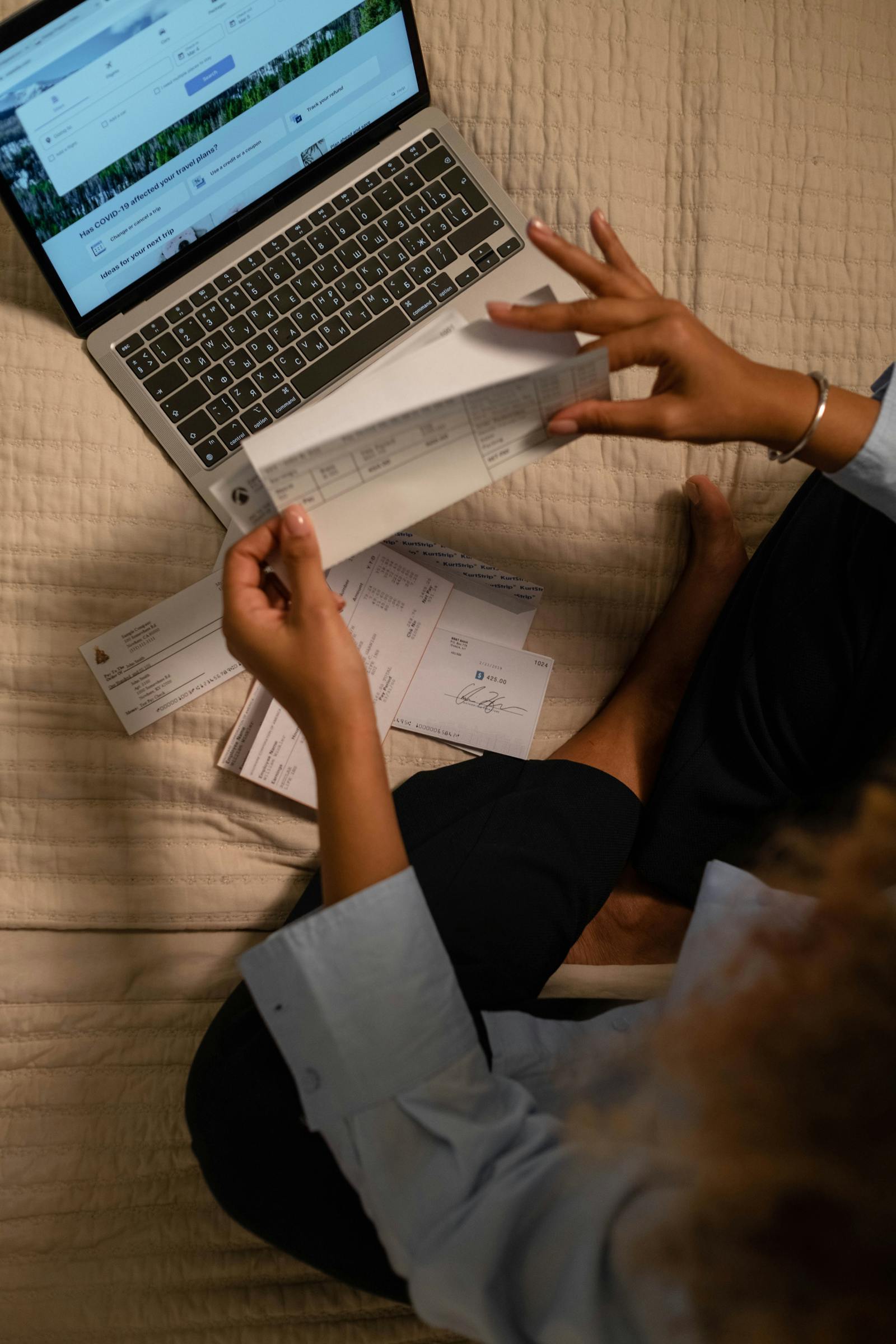 Person reviewing financial documents and paychecks at home