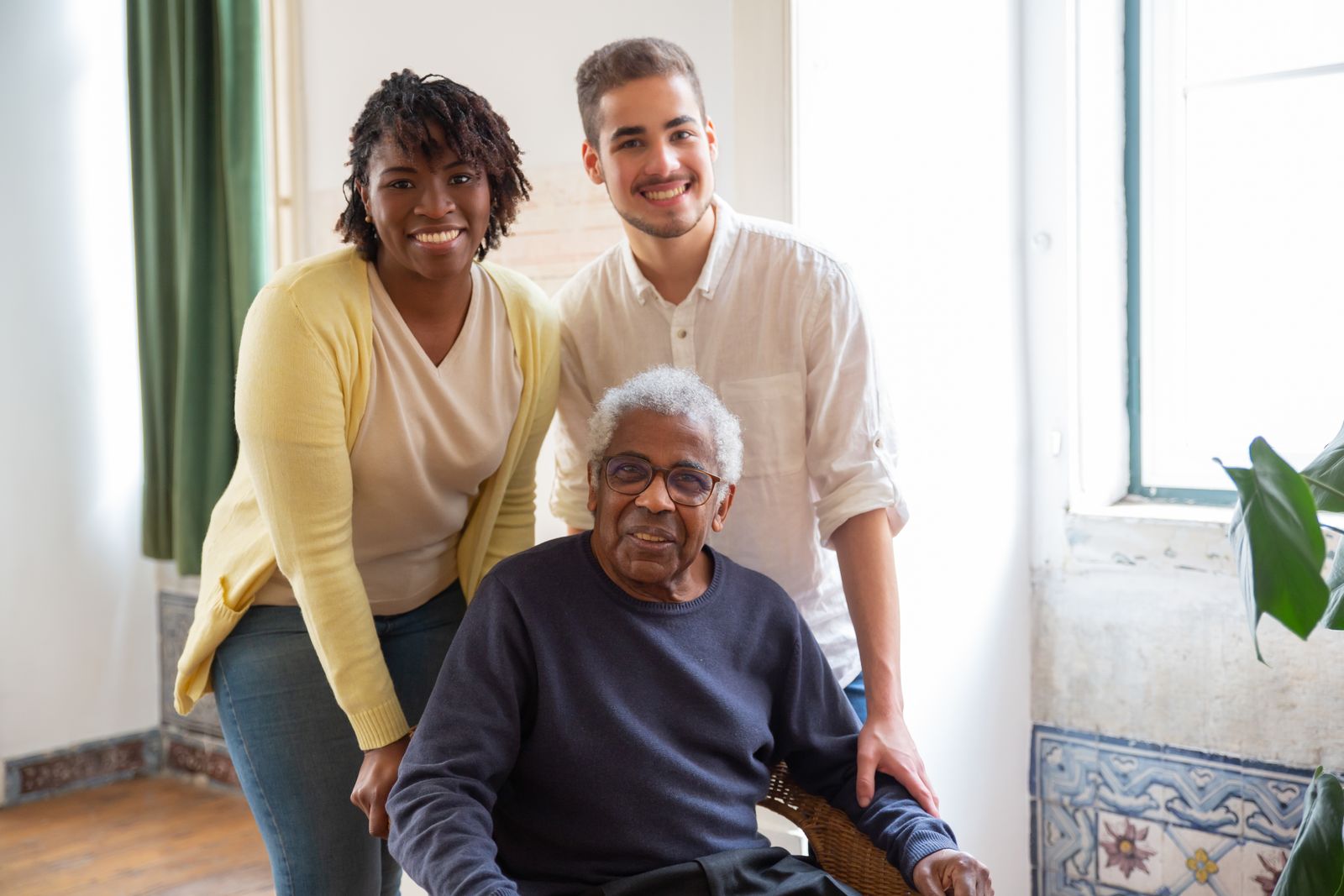 Adult children with their elderly father in a cool indoor setting during an Orange County summer day, multigenerational family check-in