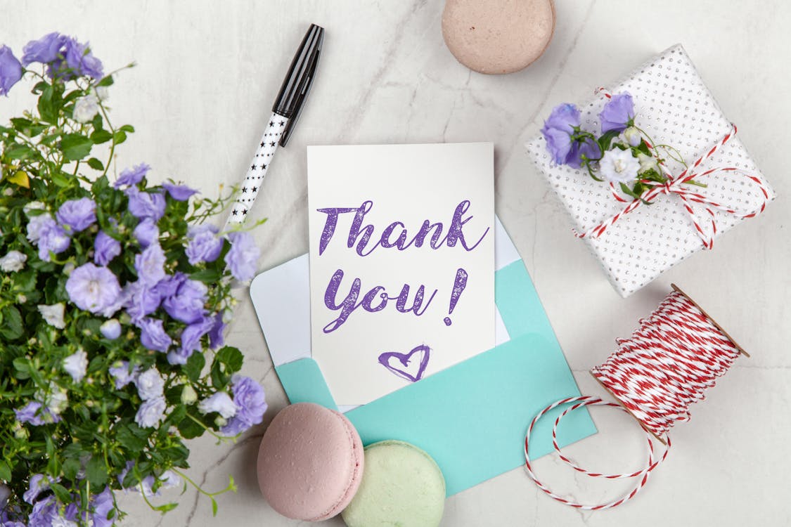 Thank you card with flowers on marble desk — caregiver appreciation gesture