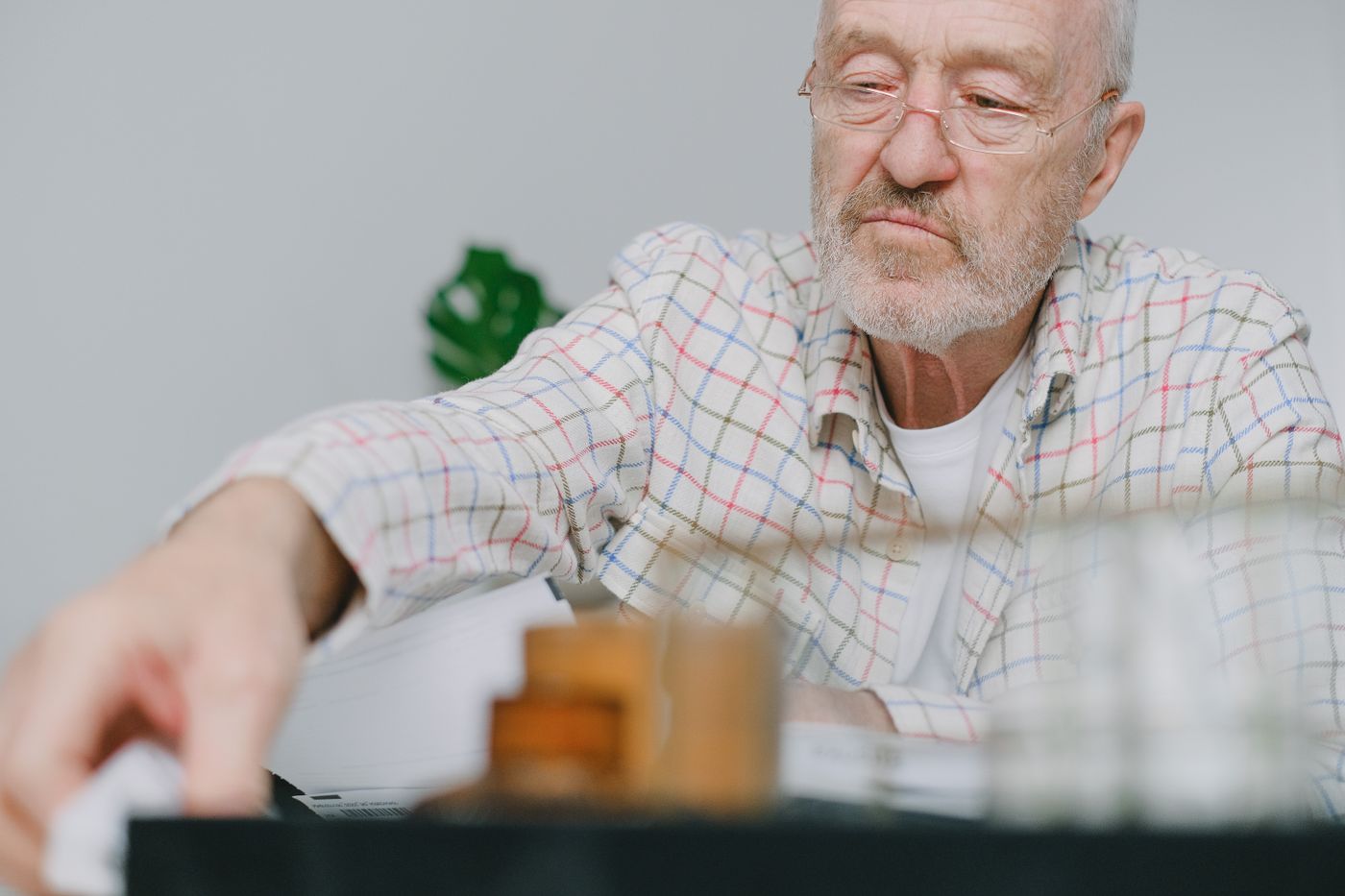 Elderly man focused on an indoor tabletop activity, illustrating a safe and engaging at-home alternative for July 4th
