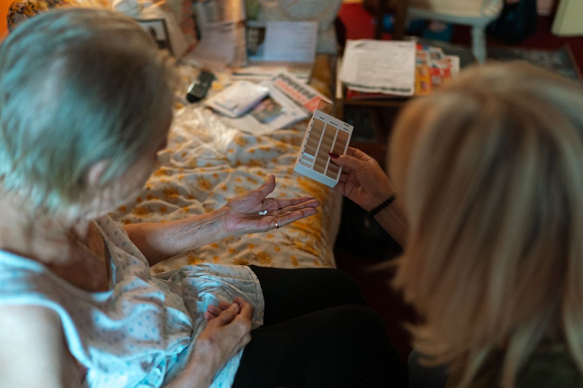 A caregiver helps an Orange County senior with medication management under the GUIDE Model