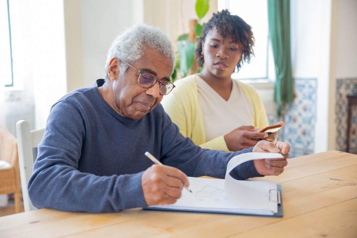 Senior man working with caregiver to document care hours and protect IHSS eligibility