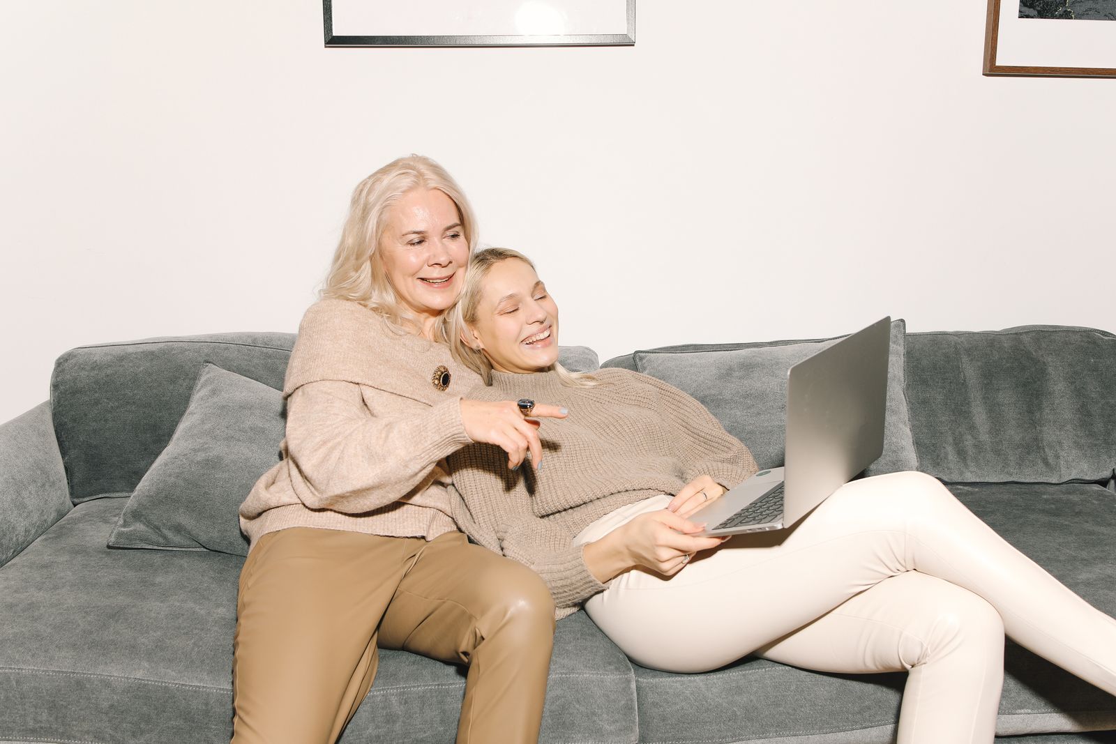 A mother and adult daughter reviewing a benefits portal together on a laptop at home