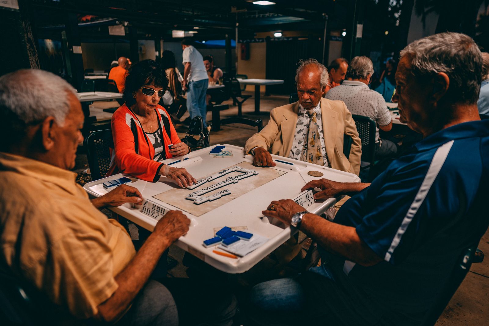 A group of seniors gathered around a table playing a game together, socializing during the day