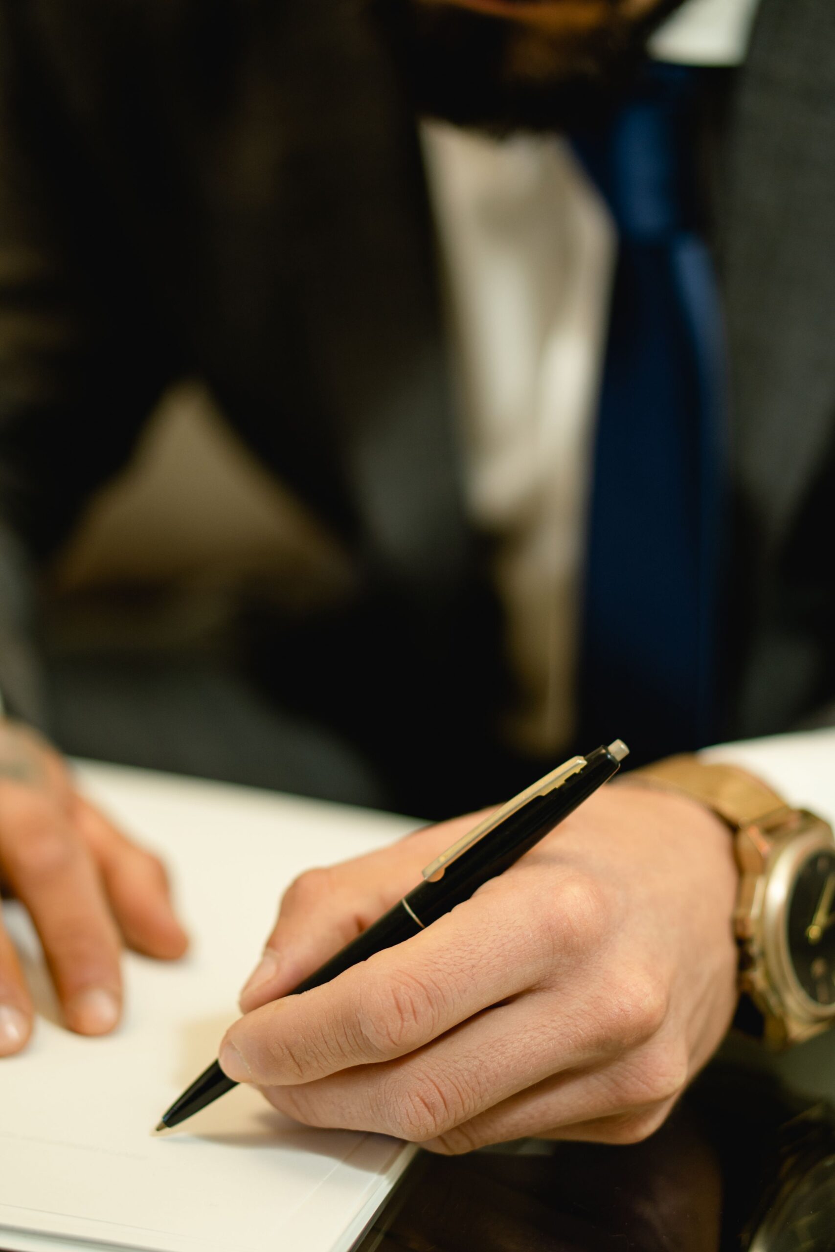 Close-up of a hand signing a legal contract document with a pen