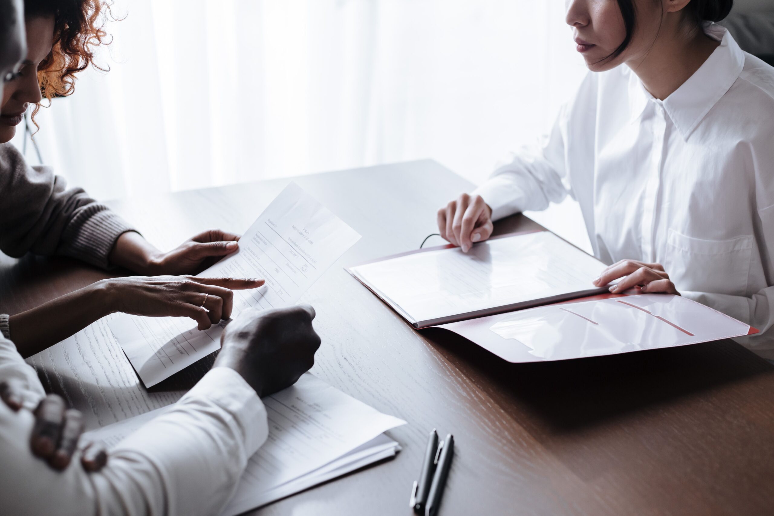 Two people reviewing entrance-fee contract paperwork together at an office table