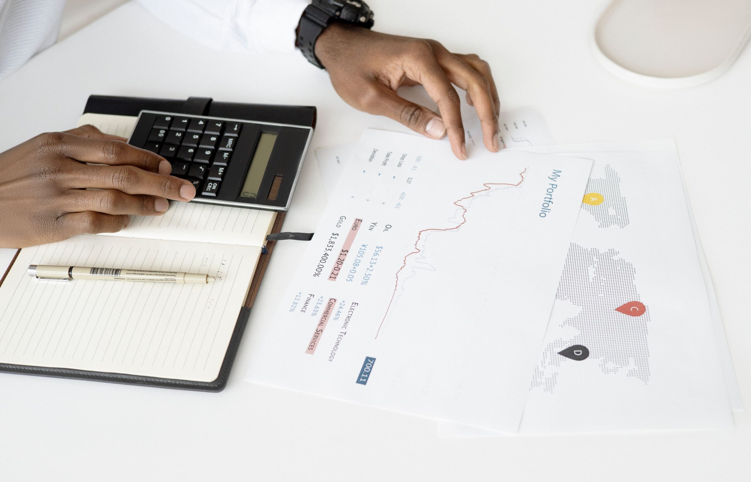 Overhead view of a person using a calculator while reviewing financial account statements