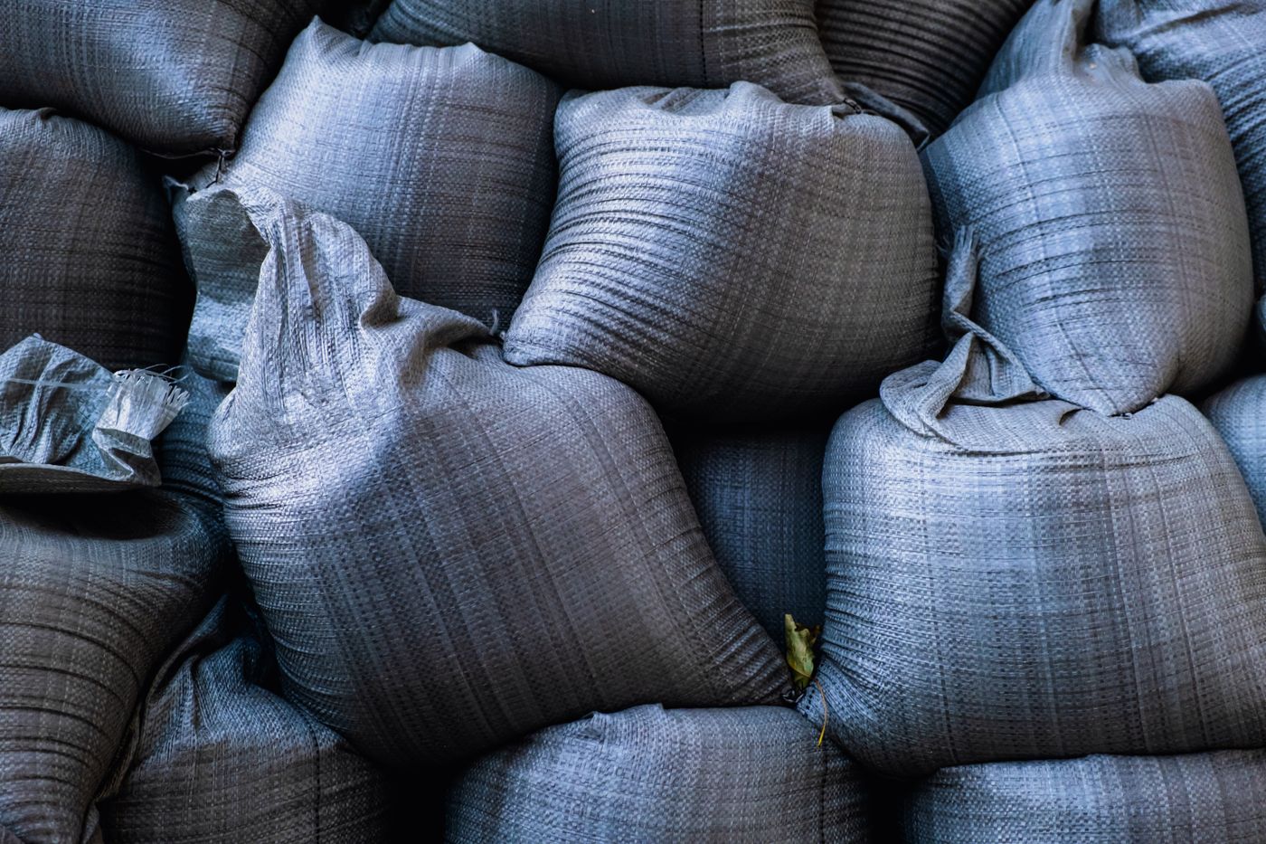 Close-up of stacked woven sandbags used as a flood barrier