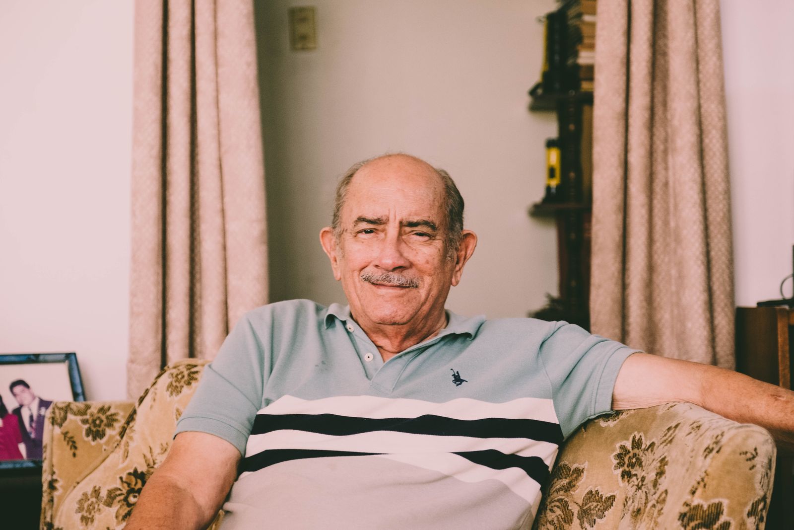 Older man sitting comfortably in his living room at home