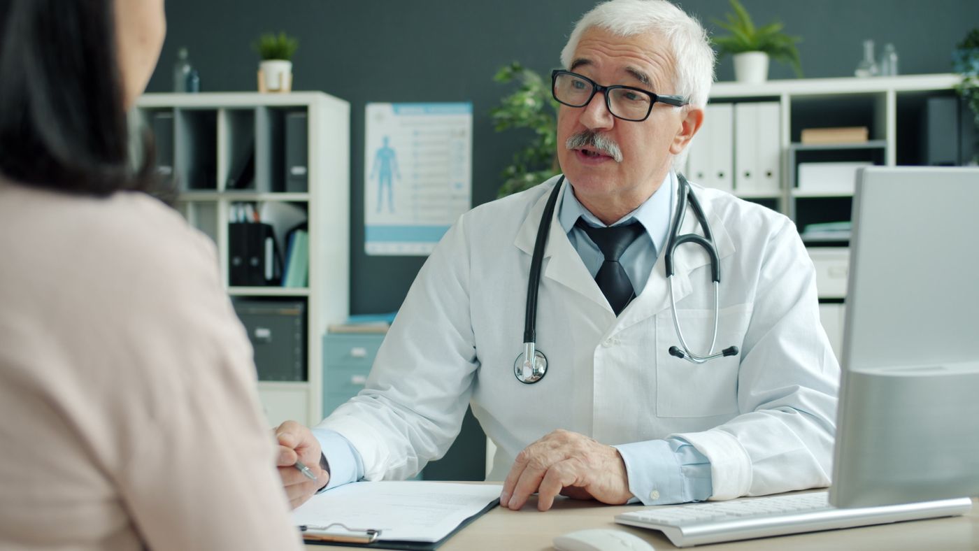 Senior patient in consultation with an older physician discussing a Medicare Advantage network change