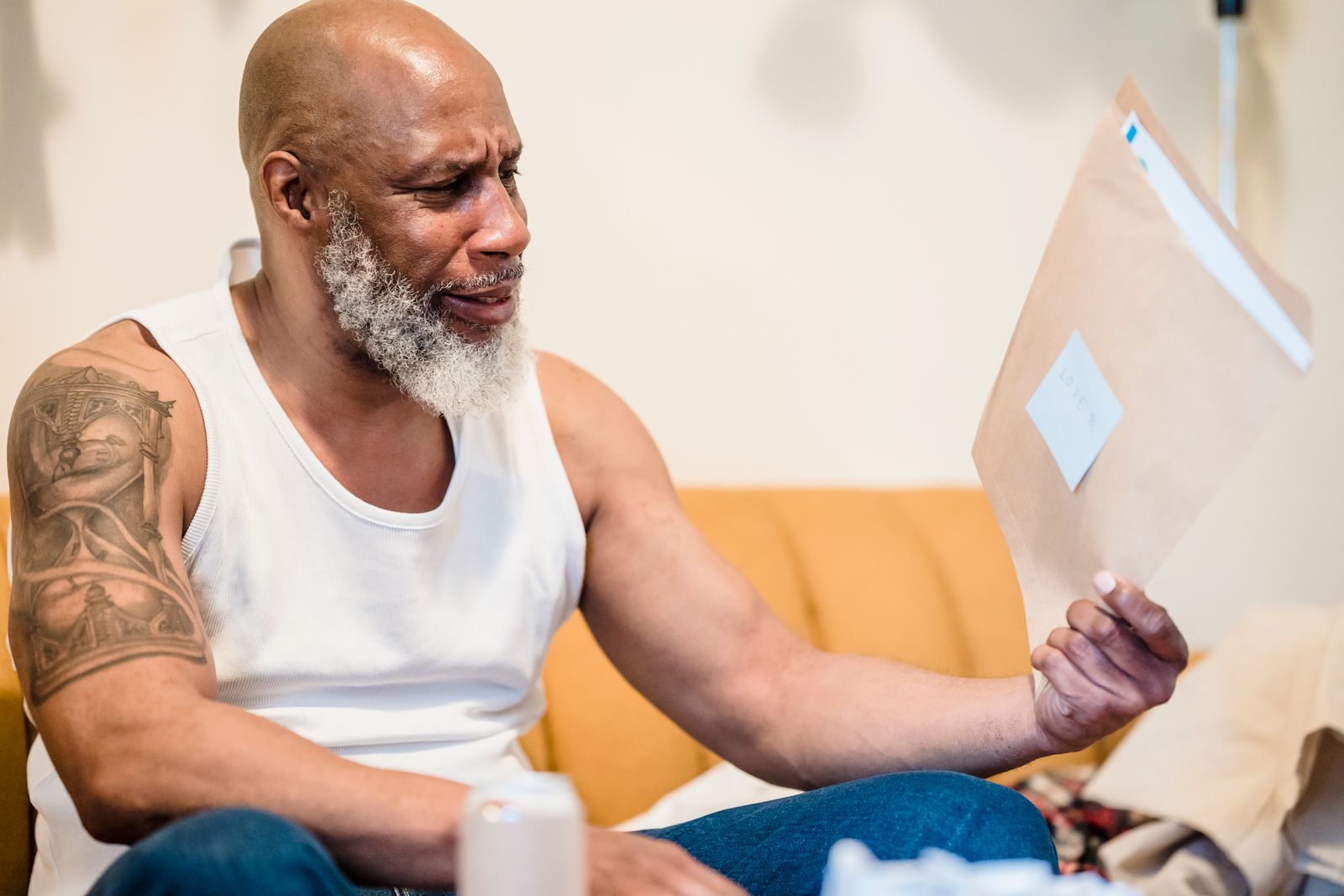 A concerned senior man reads an official letter at home, representing a Medicare Advantage prior authorization decision
