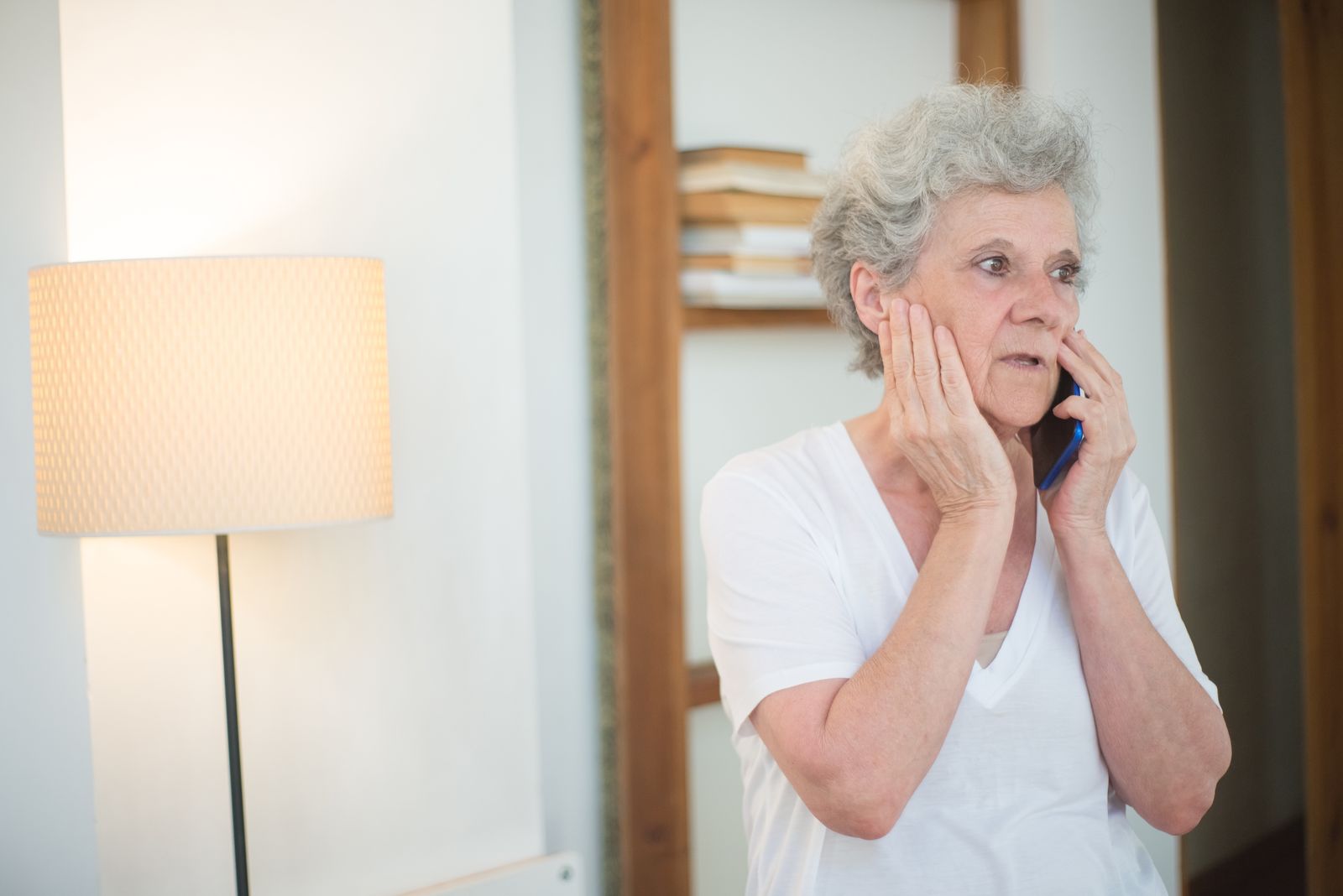 Concerned senior woman on the phone at home, representing a call placed to the BFCC-QIO to file a fast appeal