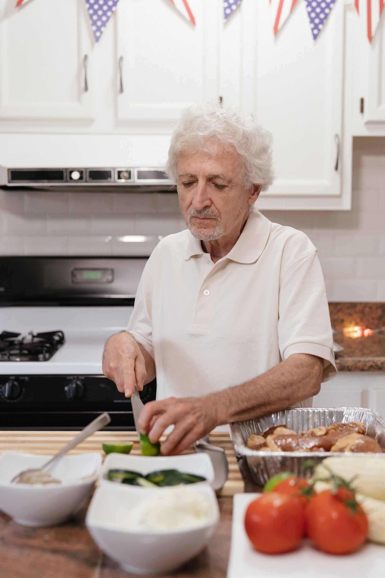 A senior man prepares a home-cooked meal from fresh ingredients in his kitchen