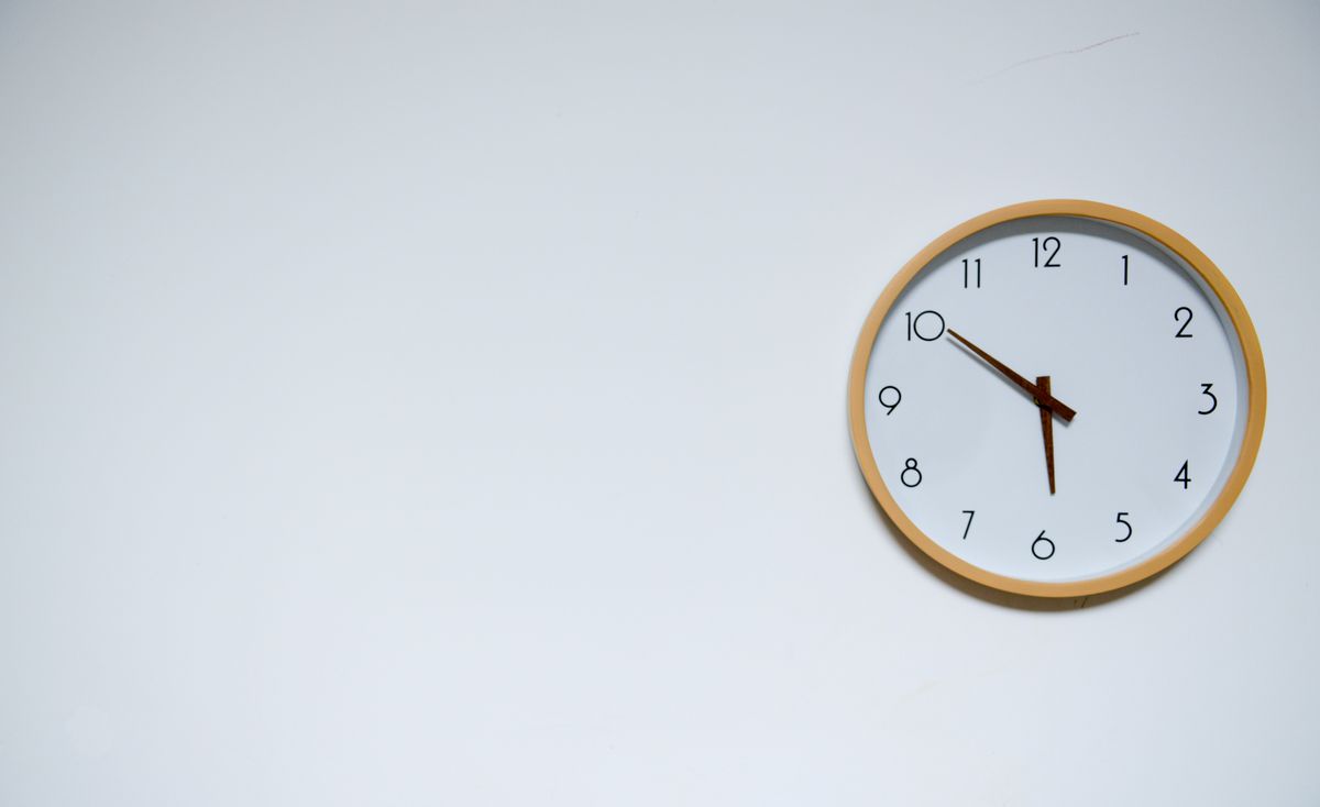 Simple round wall clock on a plain white wall