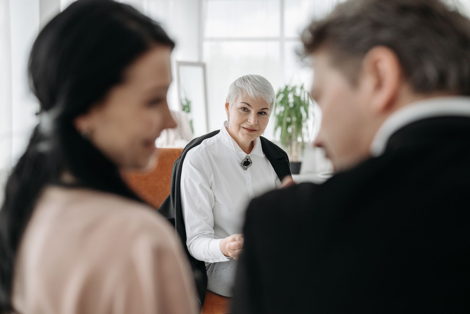 A couple sits across from an advisor discussing paperwork during a consultation