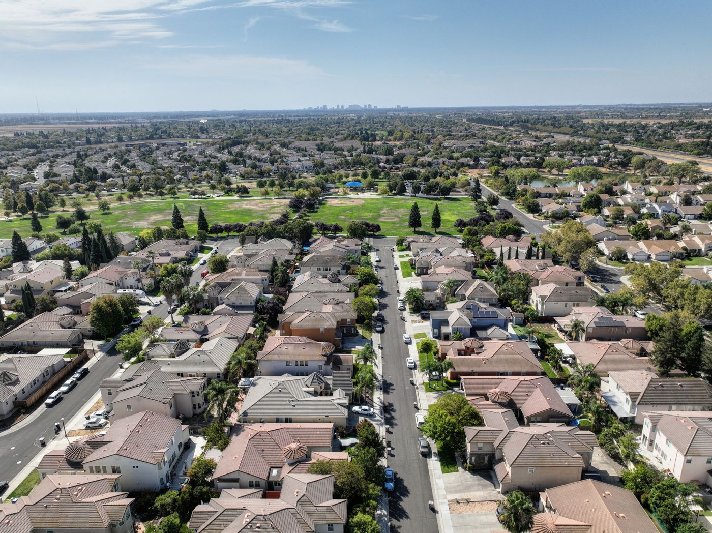 Aerial view of a Southern California suburban neighborhood with tile-roofed homes and tree-lined streets